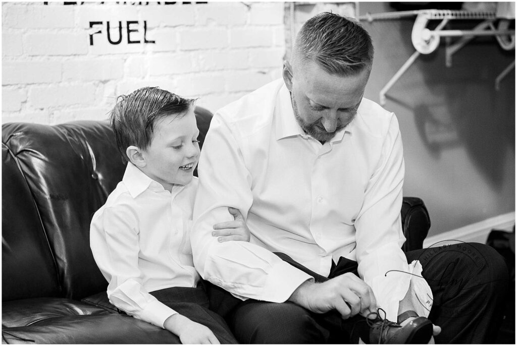 groom helping a young boy tie his shoes