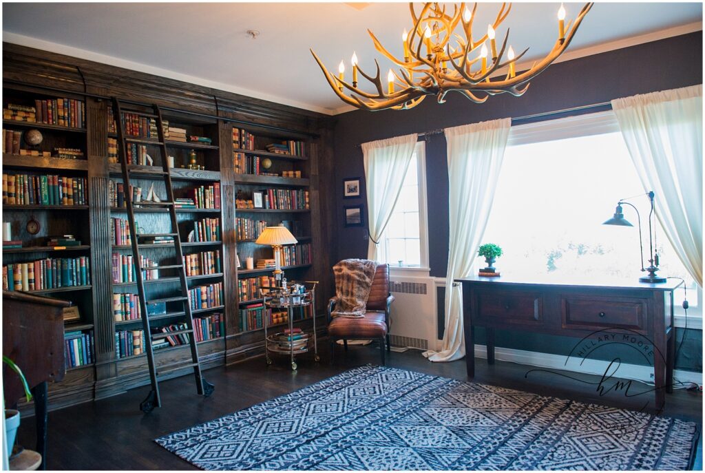 Mahogany wood decorated library with antler chandelier.