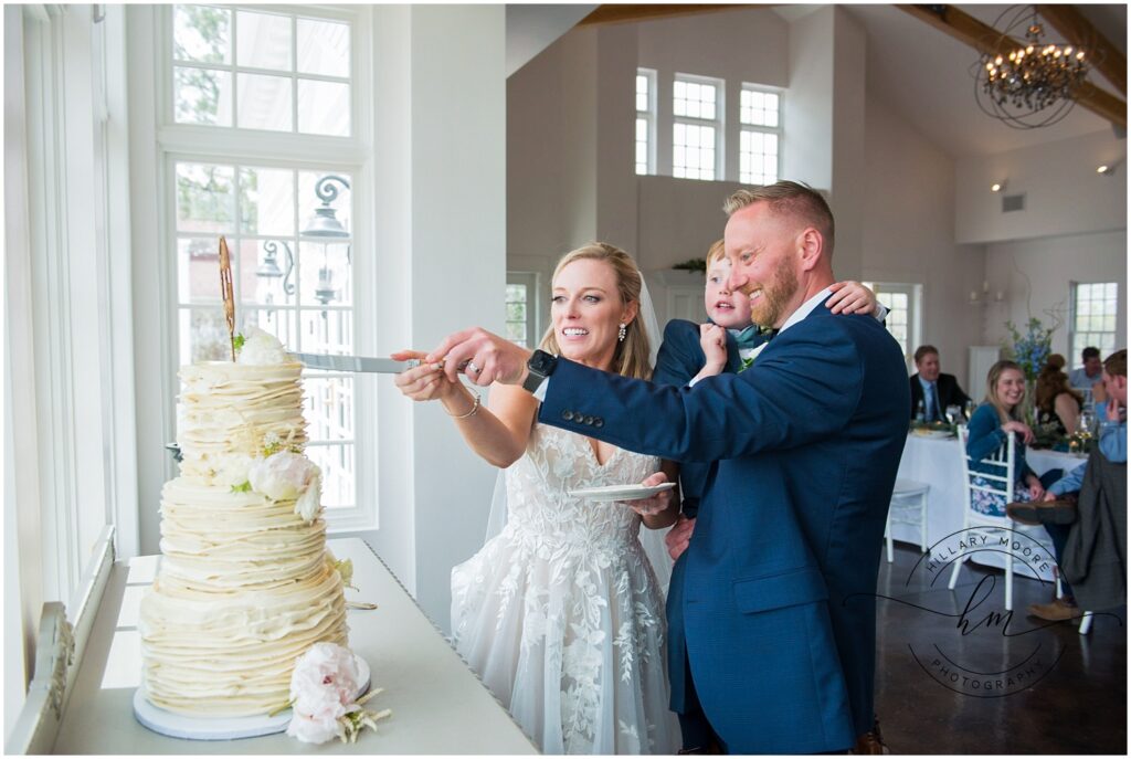 The bride and groom cutting a cake.