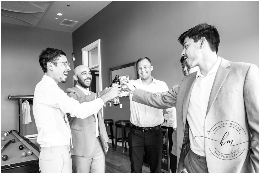 groom and groomsmen having a toast before the wedding.