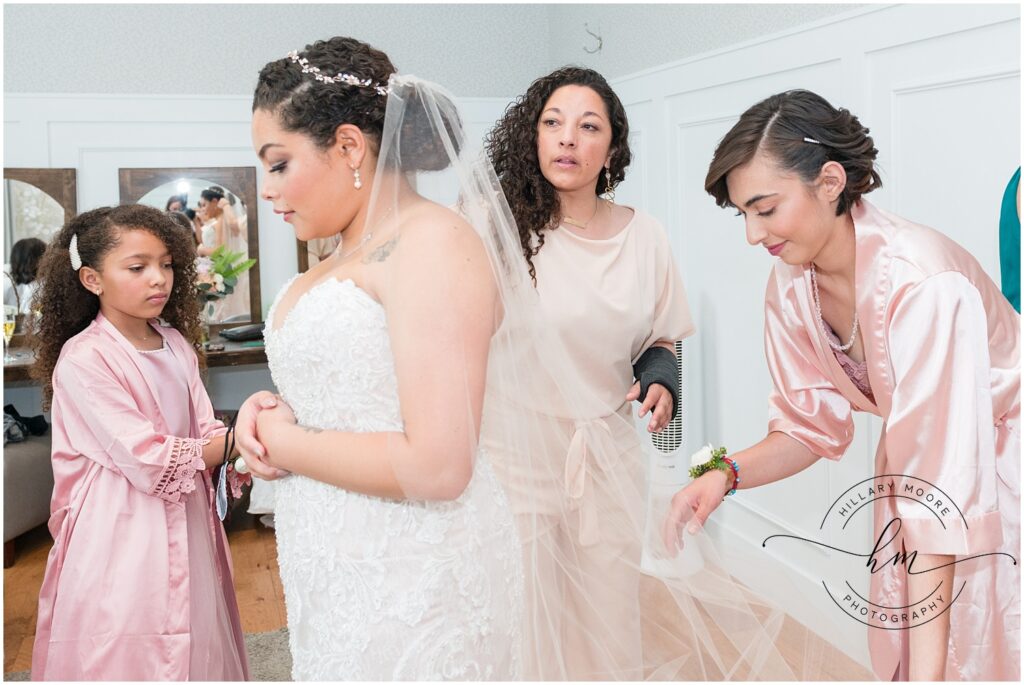 Bridesmaid adjusting the brides veil.