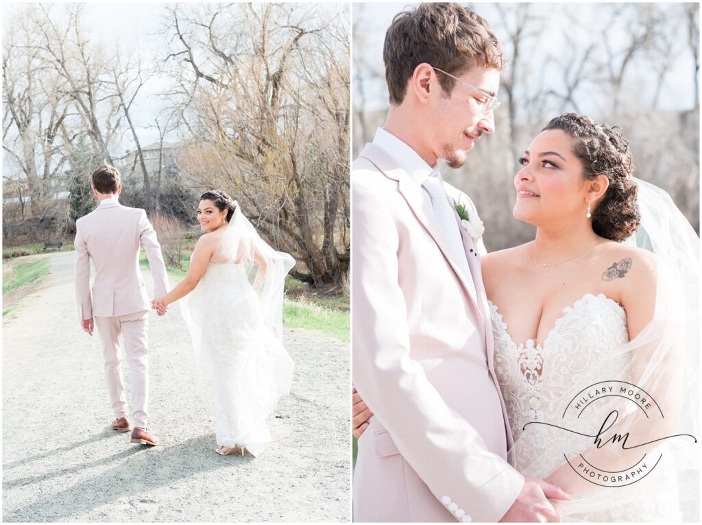 Bride and groom walking down gravel road together holding hands.