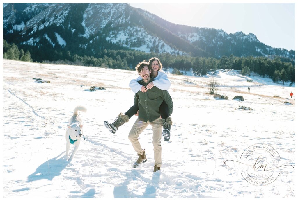 couple in snowy field with dog