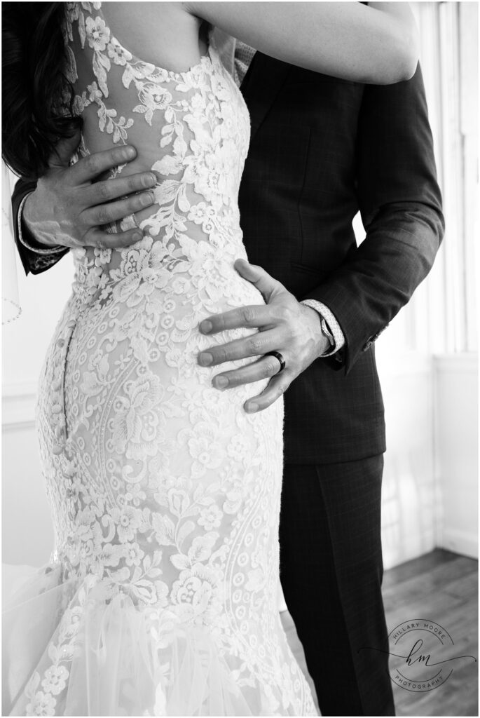 Groom holding his bride closely as they kiss.